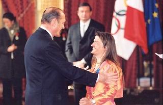 Le Président de la République remet à Melle Anne Floriet les insignes d'officier dans l'Ordre national du Mérite.